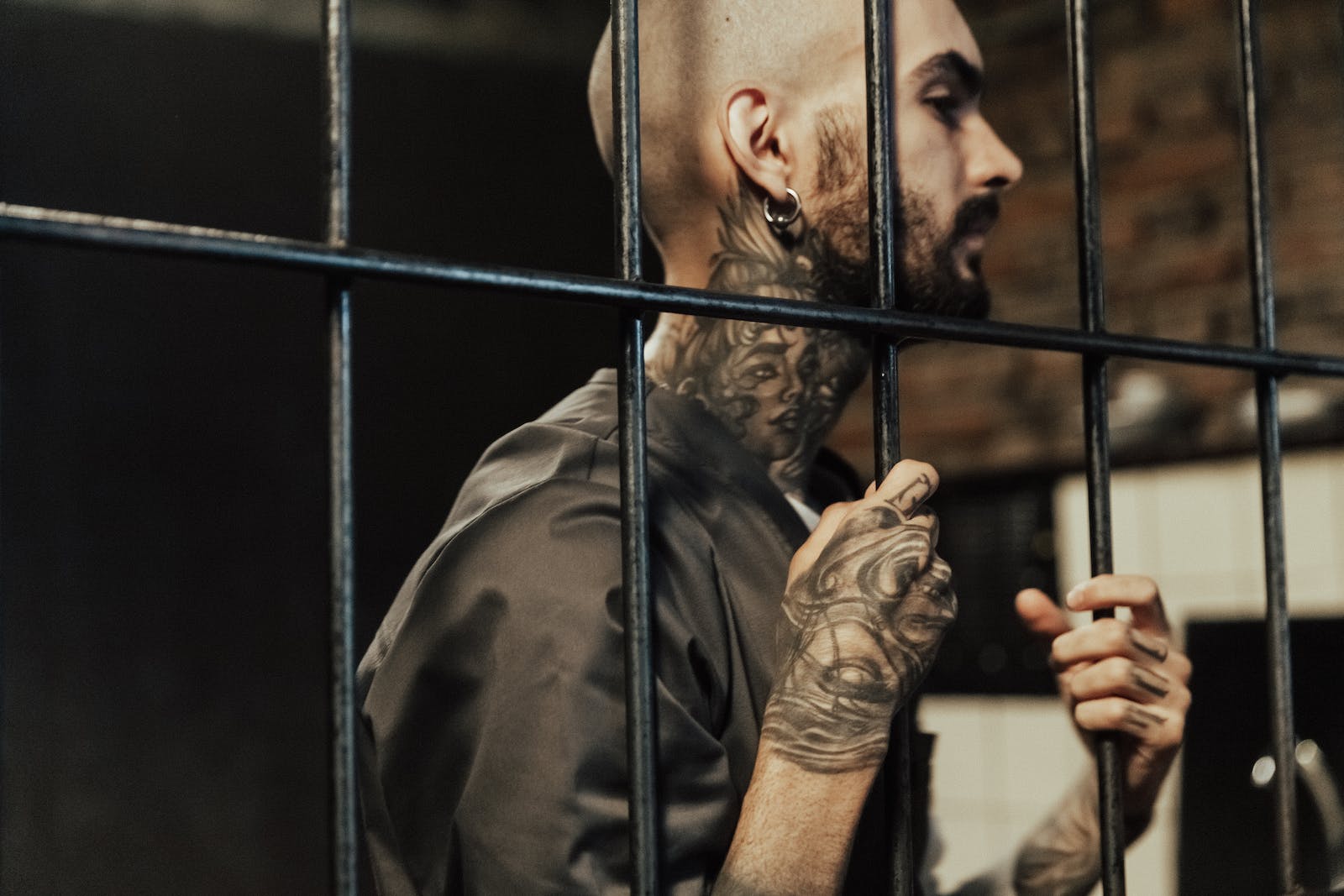 man in jail with body tattoos on his arm and neck