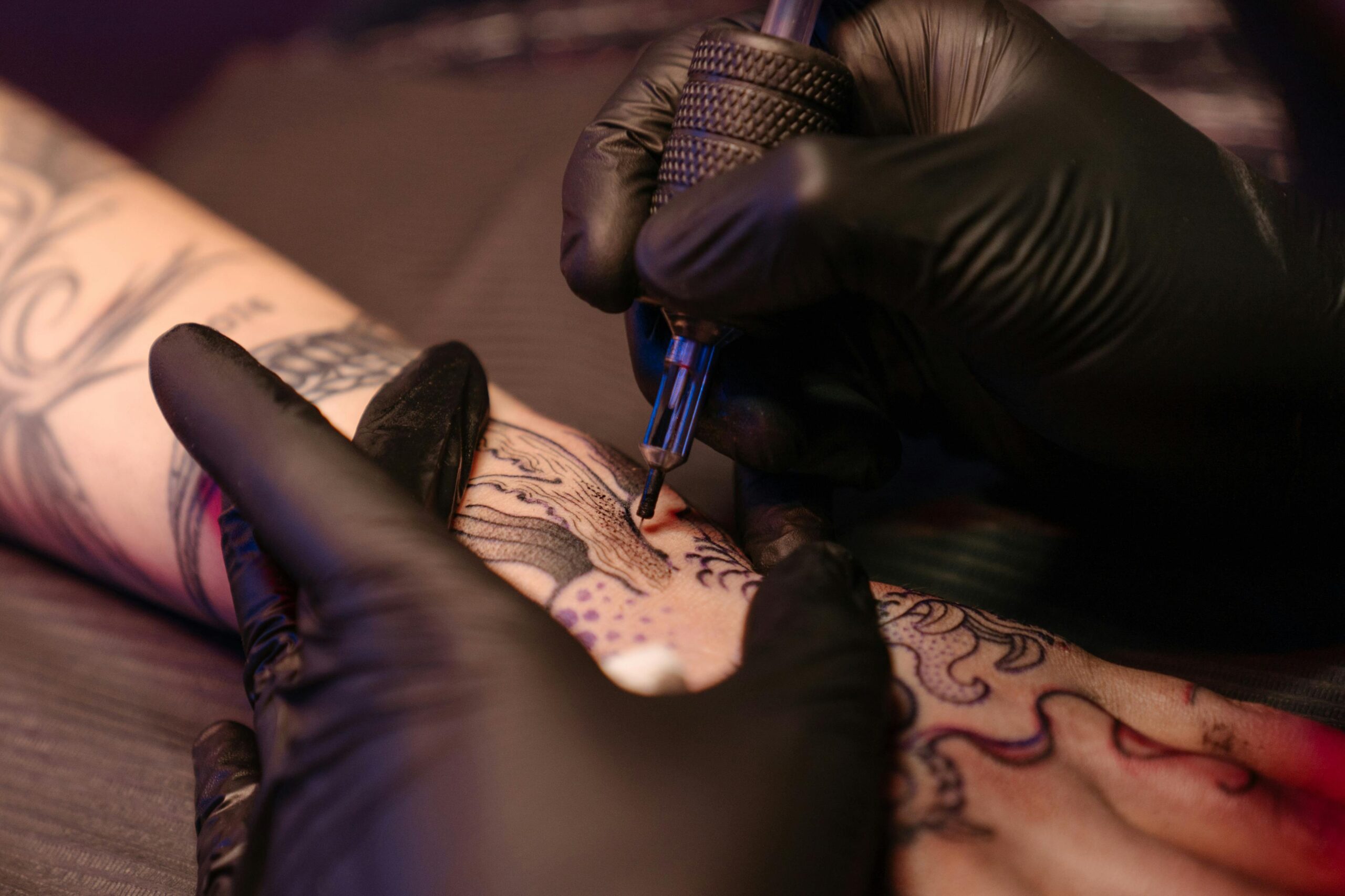 man getting a color tattoo on his wrist area