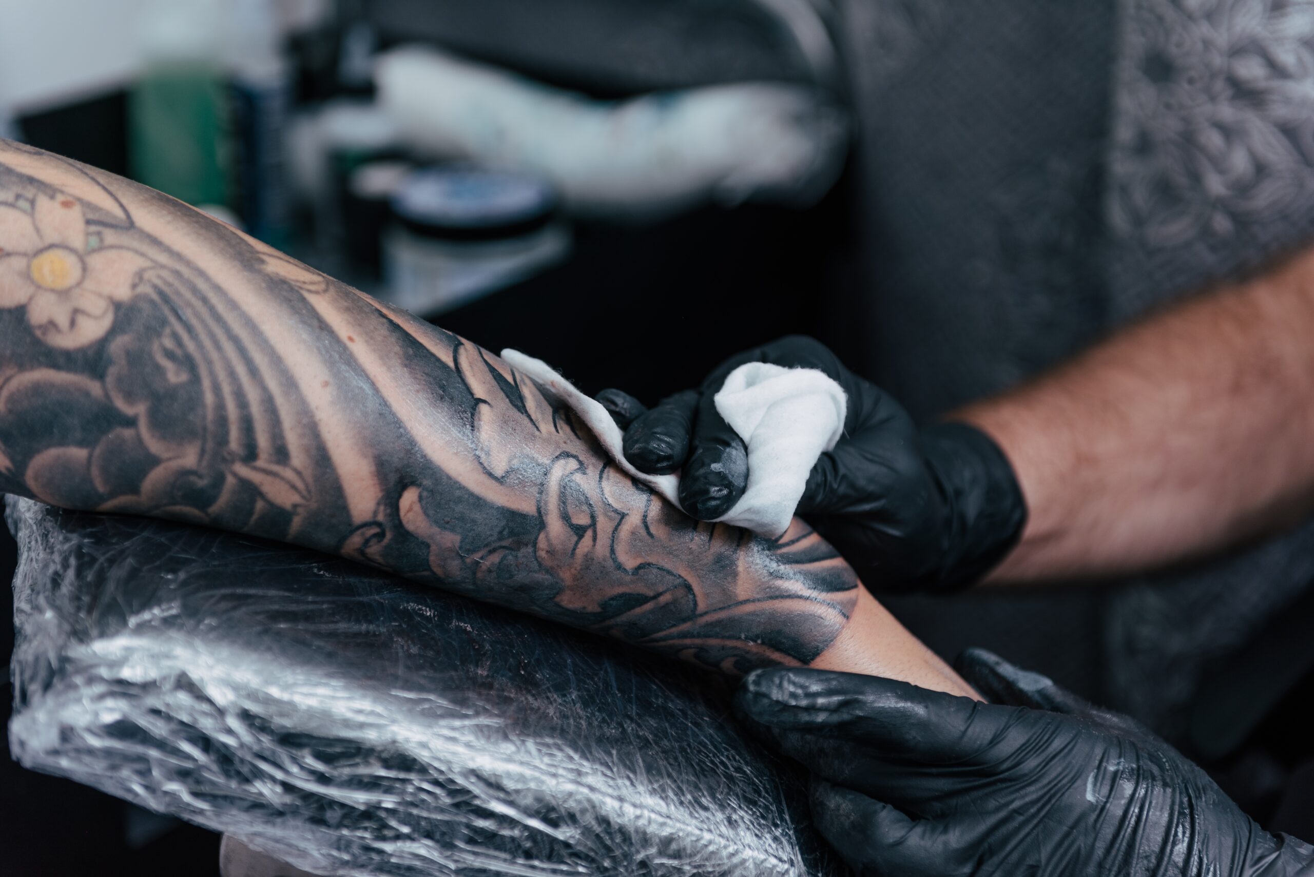 a person getting their arm tattoo finished